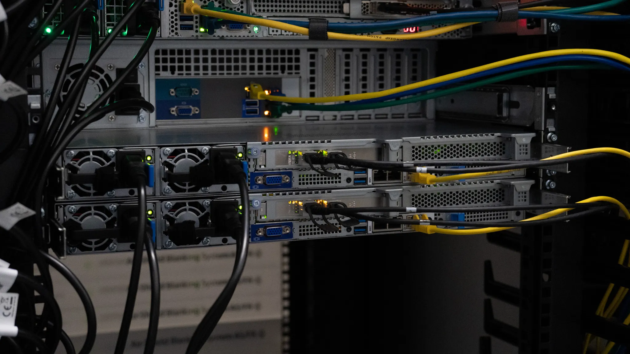 Server im eigenen Rack von Prepaid-Hoster, mit gelben und blauen Netzwerkkabeln